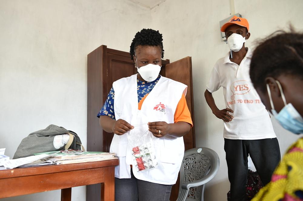 An MSF nurse and laboratory assistant from the Ministry of Health, explaining to a patient how to properly feed her child the ready-to-use therapeutic foods (RUTF) to help care for the malnourished child. 